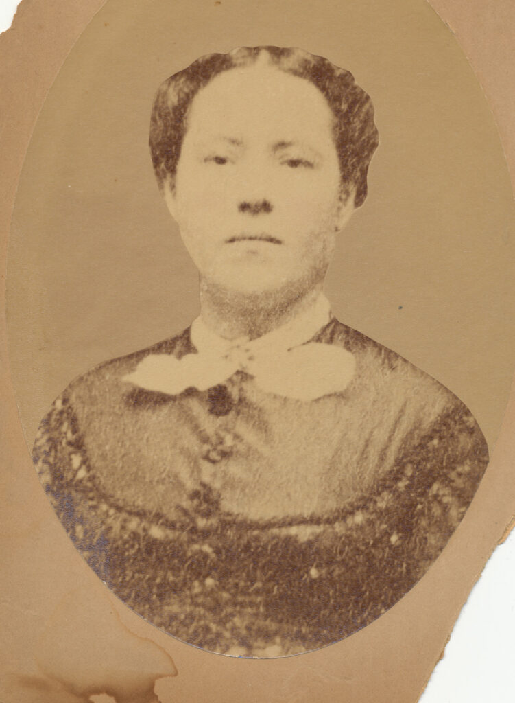 Mary Parker in sepia, wearing a false-yoke style shirt and white collar. Her hair is pinned back.